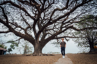 Full length of woman standing on tree