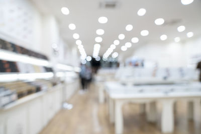 Defocused image of illuminated lights on glass at restaurant