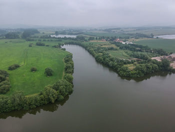 High angle view of river amidst green landscape against sky