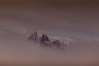 Dolomite peaks peeking through the clouds at dawn, south tyrol, italy