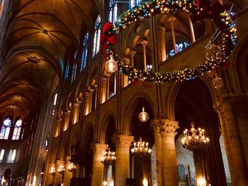 Low angle view of illuminated notre dame de paris ceiling during christmas