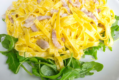 High angle view of tagliatelle pasta served with meat and herbs in plate