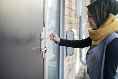 Woman with key next to door
