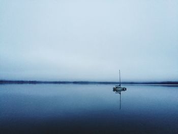 Sailboat in sea against clear sky