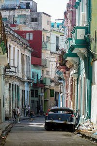 Cars on road by buildings in city