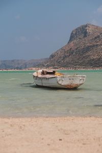 Ship moored on sea against sky