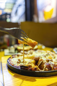 Close-up of hand holding ice cream on table