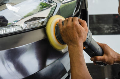 Midsection of man working in car