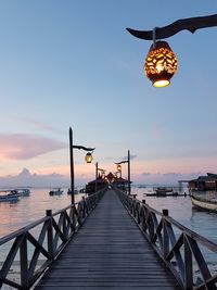 Pier over sea against sky during sunset