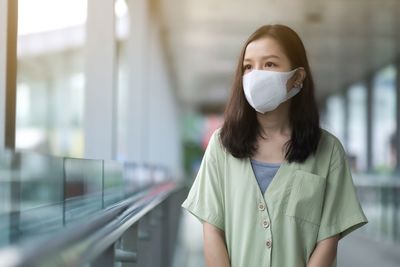 Young woman wearing mask while looking away