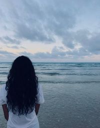 Rear view of woman looking at sea against sky