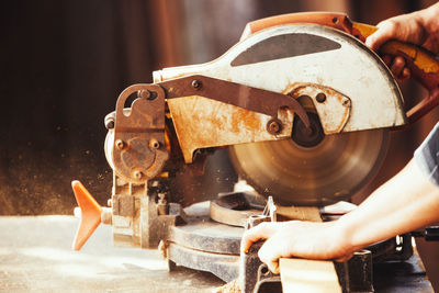 Caucasian man carpenter cutting wood with circular saw creating new furniture person