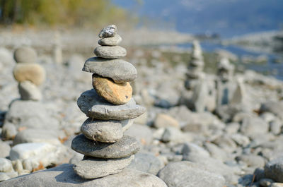 Stack of pebbles at shore during sunny day