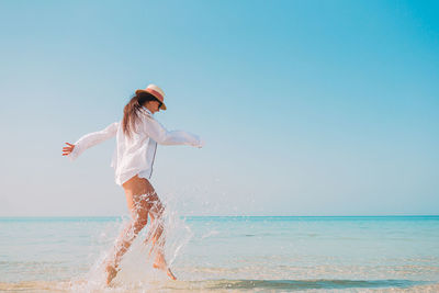 Full length of woman running at beach