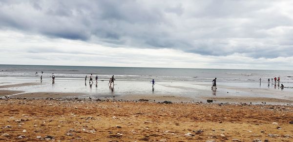 Group of people on beach against sky