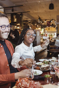 Male and female friends having dinner during part at restaurant