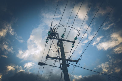 Low angle view of silhouette electricity pylon against sky