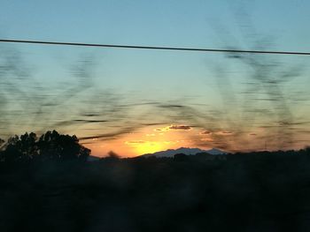 Scenic view of silhouette trees against sky at sunset