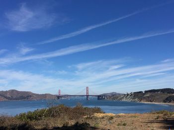 Suspension bridge over sea against sky