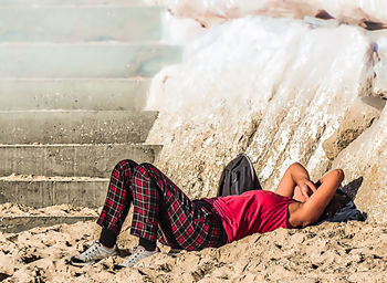 Low section of woman relaxing on beach