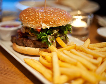 Close-up of hamburger with french fries in plate on table