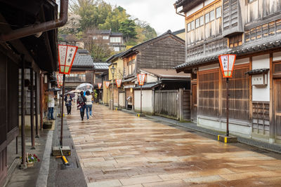 People walking on street amidst buildings in city