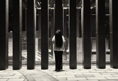 Rear view of woman standing on footpath