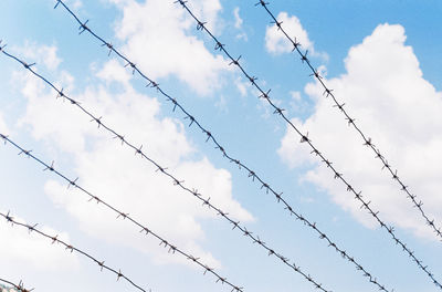 Low angle view of silhouette fence against sky