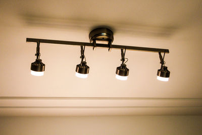 Low angle view of illuminated lights mounted on ceiling