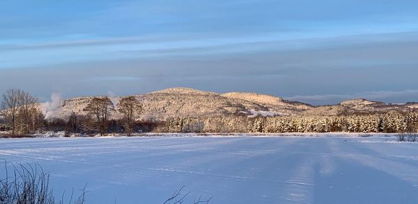Snow covered landscape against sky