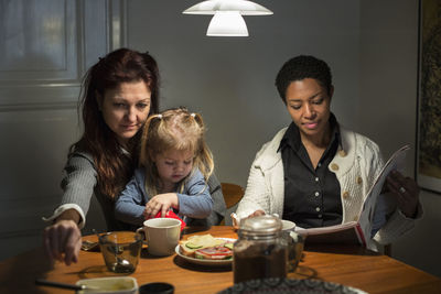 Lesbian couple eating breakfast with kids