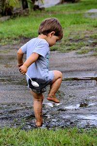 Full length of boy playing in mud