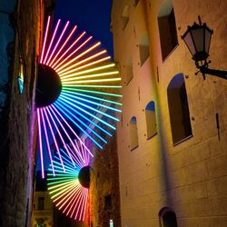 Low angle view of illuminated lighting equipment on building