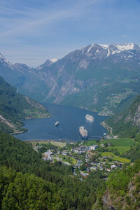 Aerial view of townscape by mountains against sky