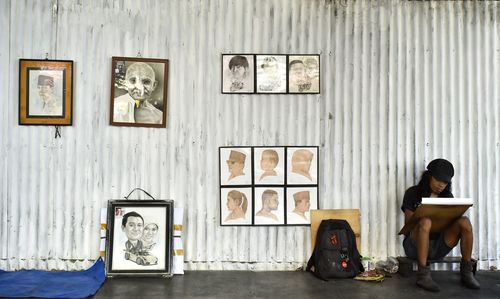 Full length of woman sitting on wall