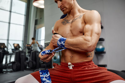 Shirtless man exercising in gym