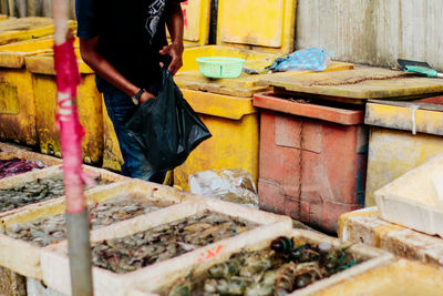 Midsection of man standing at fish market