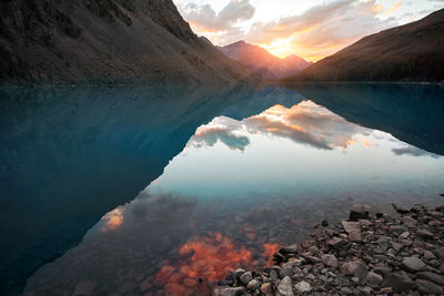 Scenic view of lake by mountains against sky