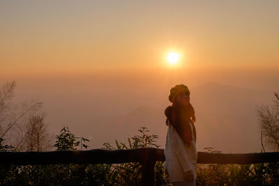 Portrait of woman standing against sky during sunrise