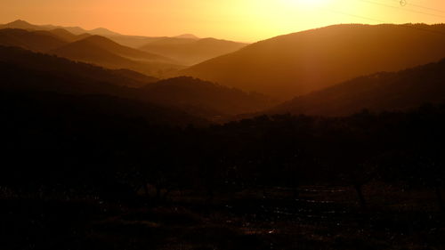 Scenic view of silhouette mountains against sky during sunset