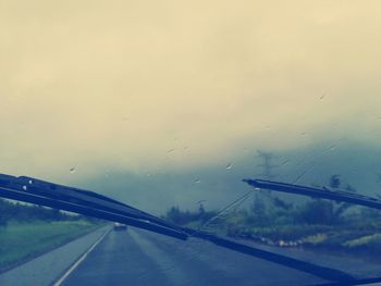 Car on road against cloudy sky