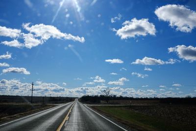 Road amidst landscape against blue sky