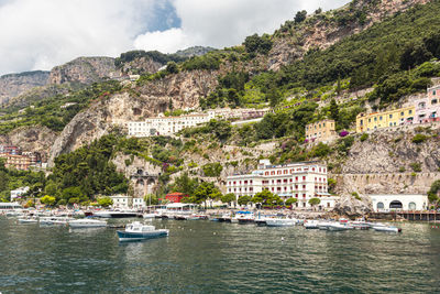 Panoramic view of small haven of amalfi village with turquoise sea and colorful houses on slopes 