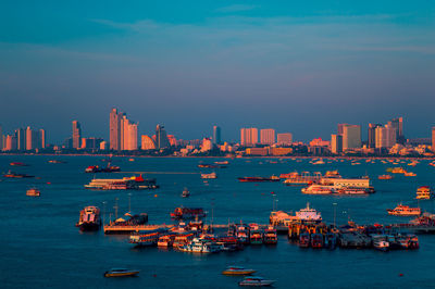 Boats in sea against sky in city