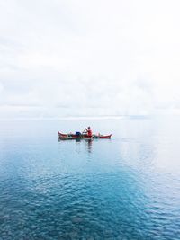 Men in sea against sky