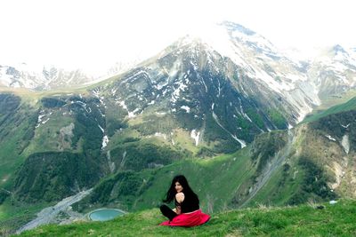 Portrait of woman sitting against mountain