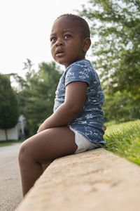 Portrait of boy sitting on tree