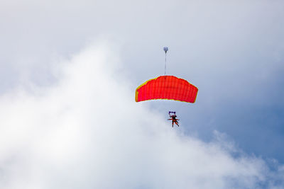 Low angle view of person paragliding against sky