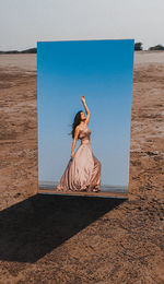 Woman standing at beach against sky