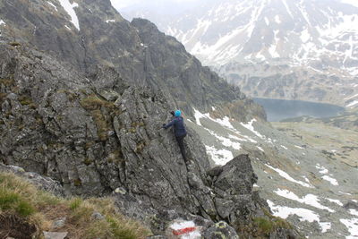 High angle view of hiker climbing snowcapped mountain